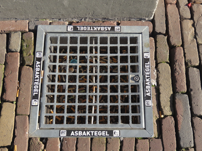 902283 Afbeelding van een goed gevulde 'Asbaktegel', naast de entree van het pand voor de opvang van dak- en thuisloze ...